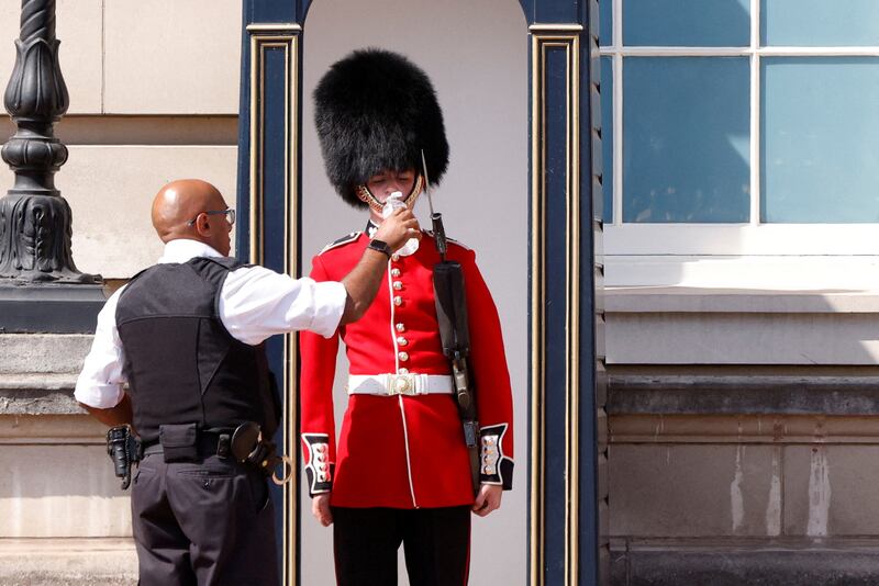 A member of the Queen's Guard is given a drink of water outside Buckingham Palace in London, in July. Reuters