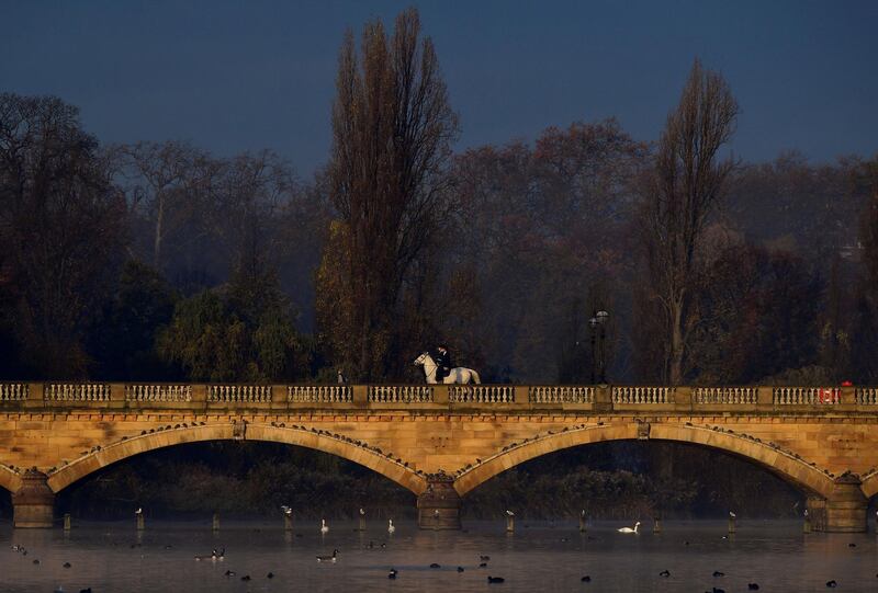 Horse riders cross a bridge over the Serpentine lake in Hyde Park, London, Britain.  Reuters
