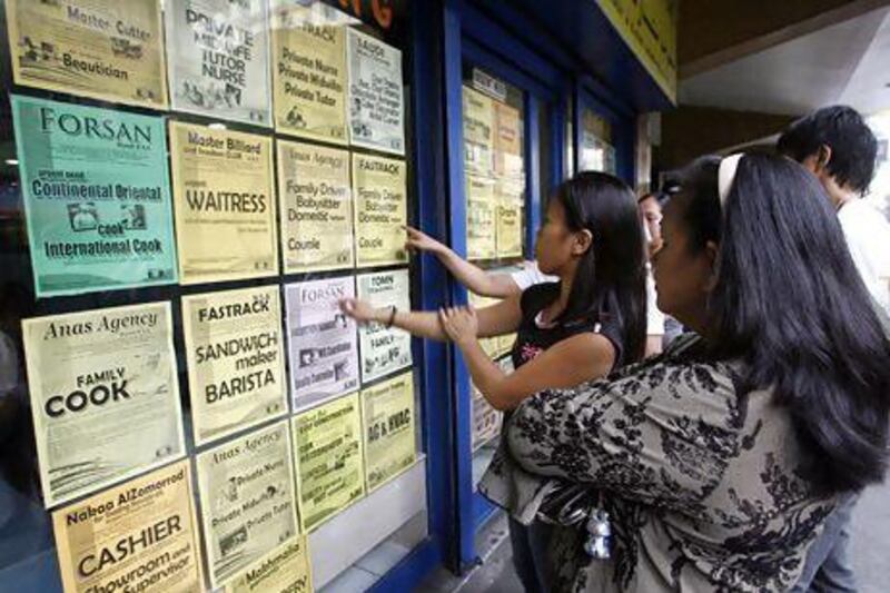 Applicants look at job offers at a recruitment agency in Manila. Cheryl Ravelo / Reuters