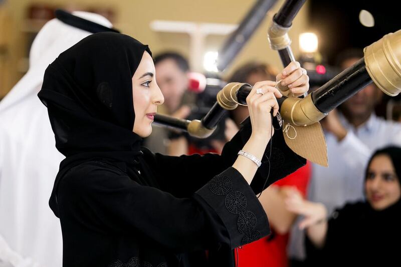 Shamma Al Mazrui, Minister of State for Youth Affairs and head of the Youth Council, places her pledge to help combat climate change on a tree made out of recycled material. She was attending a Youth Circle meeting in Sharjah. Reem Mohammed / The National