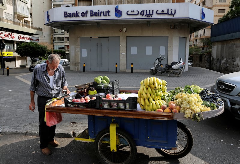 A street vendor stands by his cart near a closed Bank of Beirut branch in Beirut, Lebanon. Reuters