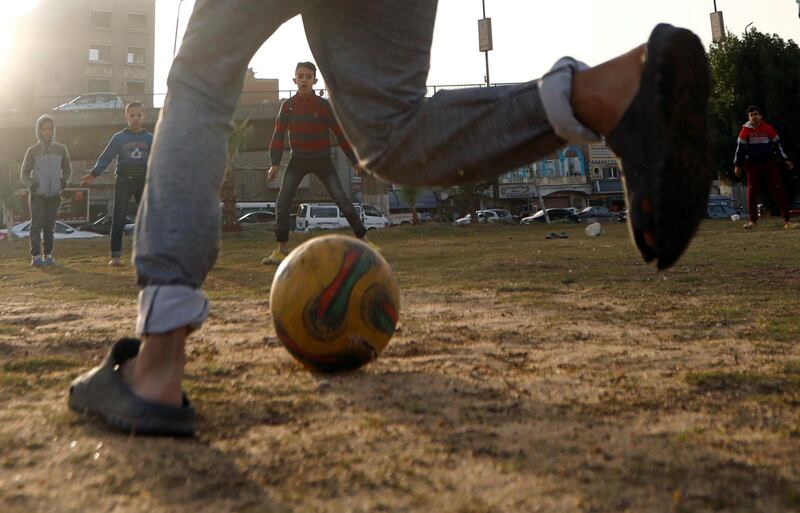 Children play football on a dusty field in Cairo, Egypt. Reuters