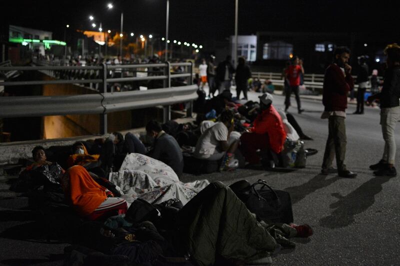 Refugees and migrants gather on a bridge as fire burns at the Moria refugee camp on the northeastern Aegean island of Lesbos, Greece. AP Photo