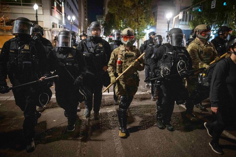 Soldiers with the National Guard help local police disperse antifascist protesters following the US presidential elections in Portland, Oregon.  EPA