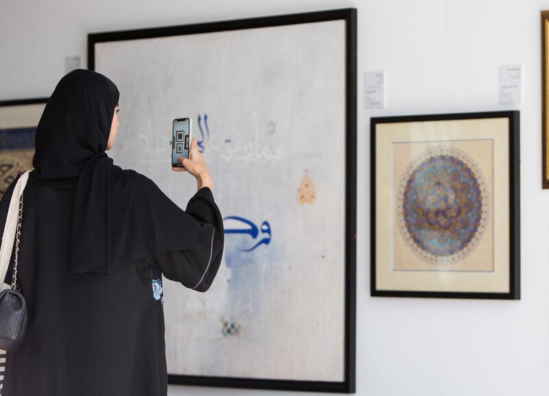 ABU DHABI, UNITED ARAB EMIRATES -A woman taking photo at an artwork at the Al Burda Festival, Shaping the Future of Islamic Art and Culture at Warehouse 421, Abu Dhabi.  Leslie Pableo for The National for Melissa Gronlund���s story