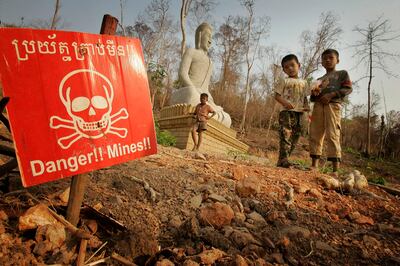 Children play near a landmine warning in New Village Border, Cambodia on March 10, 2005. Cambodia was once the most mined country in the world but has successfully cleared entire regions of the devices. AP