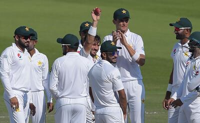 Pakistani spinner Yasir Shah (C) holds the ball as he celebrates with teammates after breaking fastest 200 wickets record during the fourth day of the third and final Test cricket match between Pakistan and New Zealand at the Sheikh Zayed International Cricket Stadium in Abu Dhabi on December 6, 2018. / AFP / AAMIR QURESHI
