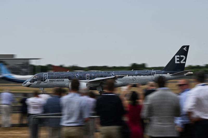Visitors watch the Embraer E2 Profit Hunter plane taking off. AFP