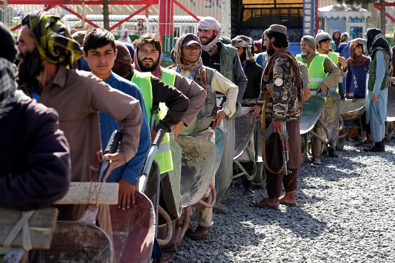 Hungry people queue for food rations distributed by a Saudi Arabian humanitarian aid group in Kabul. AP