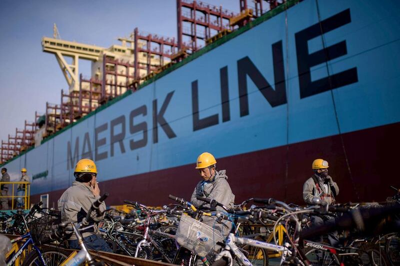 Workers take a break outside an under-construction Maersk triple-E class container ship. Ed Jones / AFP