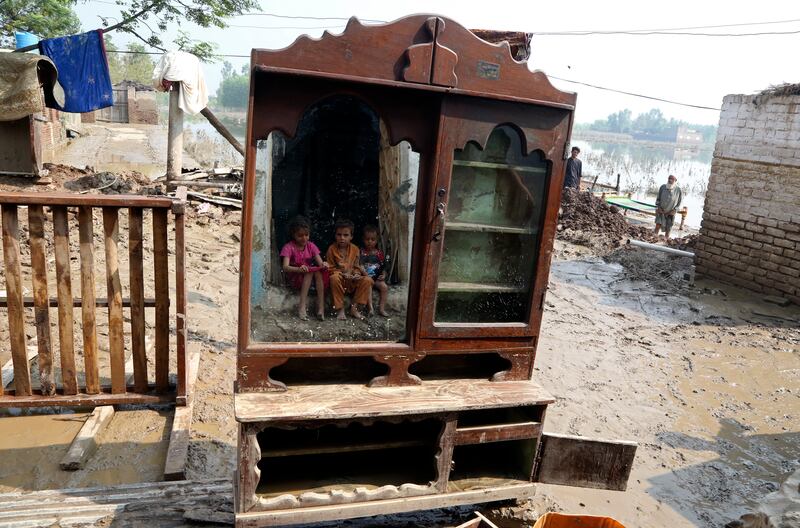 Children reflected in a mirror near their flood-hit home in Charsadda, Pakistan, where officials this week raised concerns over the spread of waterborne diseases as floodwaters began to recede in many parts of the country. AP Photo