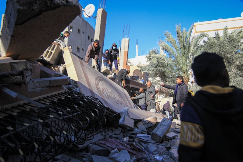 Palestinians search the site of a destroyed residential building hit by an Israeli air strike in Deir Al-Balah. Bloomberg