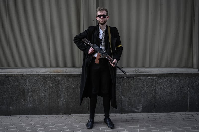 Svyatoslav Yurash, 26, a lawmaker from Zelenskyy's Servant of the People party, poses with his assault rifle as he patrols downtown Kyiv on February 27. AFP
