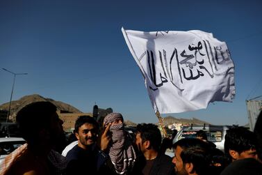 A member of the Taliban holds a flag aloft in Kabul. Reuters 