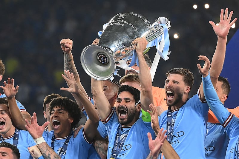 Manchester City's German midfielder #8 Ilkay Gundogan (C) lifts the European Cup trophy as they celebrate on the podium after winning the UEFA Champions League final football match between Inter Milan and Manchester City at the Ataturk Olympic Stadium in Istanbul. AFP