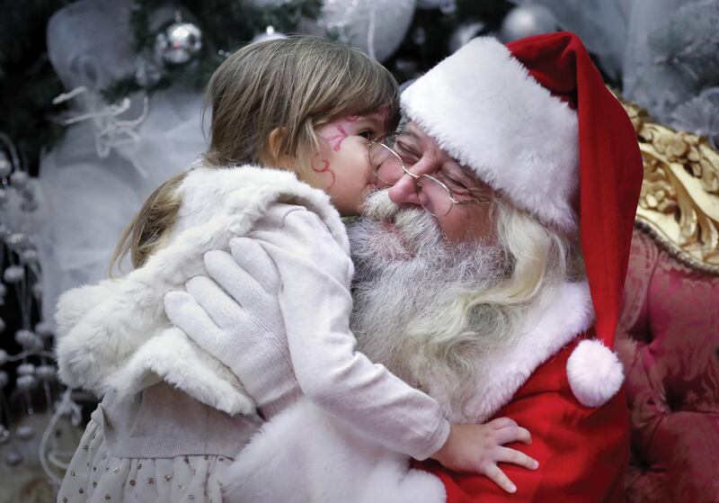 A Santa is kissed by a Romanian girl before giving her a gift at a Christmas Tree show dedicated to the children of the fallen or wounded soldiers of the Romanian Army, in Bucharest, Romania. EPA