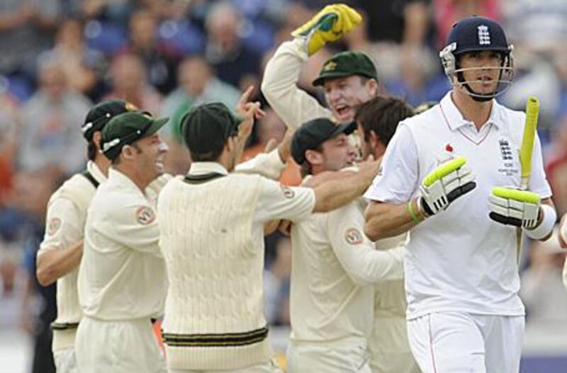 Kevin Pietersen, right, walks after in front of the celebrating Australians after being bowled by the seamer Ben Hilfenhaus.