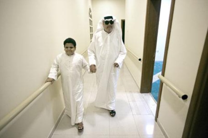 Mahmoud Najib and his teacher, Ahmed Mukhtar, walk down hallway at the EAB in Sharjah.