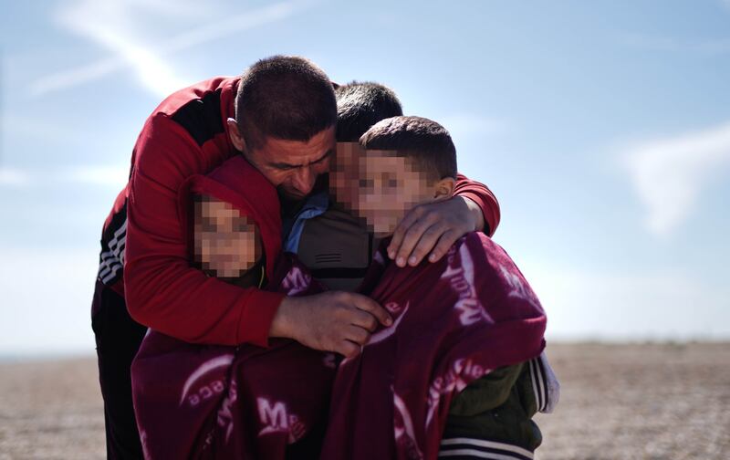 A Syrian father embraces his children in Dungeness, Kent, after being rescued in the English Channel by the RNLI. Getty Images