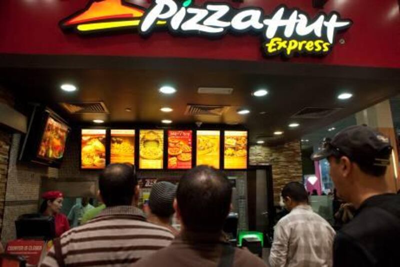 UAE - Dubai - Feb 01 - 2012:  People buying food at Pizza Hut restaurant at Dubai Mall ( Jaime Puebla - The National Newspaper )