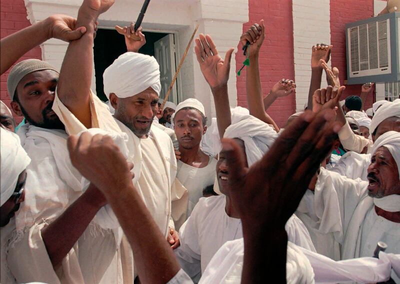 Al Mahdi is cheered by supporters as he walks out of the Wad Nubawi Mosque in Khartoum in 1996. AP