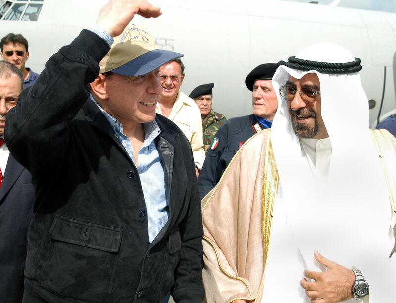 Mr Berlusconi, left, is greeted during a stopover at Kuwait airport in April 2004 after visiting Italian troops at their base in the southern Iraqi city of Nasiriyah.        AFP