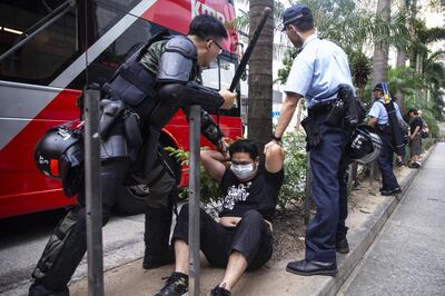 Riot police detain a pro-government supporter during clashes with pro-democracy demonstrators in the Wan Chai district of Hong Kong, China, on Tuesday, Oct. 1, 2019. Chinese President Xi Jinping stressed national unity and said relations between Hong Kong and the mainland would improve, as the city braced for a wave of protests to coincide with the 70th anniversary of Communist rule. Photographer: Chan Long Hei/Bloomberg