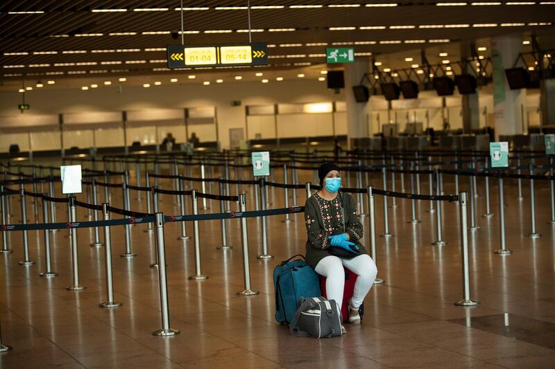 FILE - In this July 29, 2020, file photo, a passenger, wearing a face mask to protect against the spread of coronavirus, sits at the almost empty departures hall at the Zaventem international airport in Brussels. Airlines are trying to convince a frightened public that measures like mandatory face masks and hospital-grade air filters make sitting in a plane safer than many other indoor settings during the coronavirus pandemic, but it isnâ€™t working.(AP Photo/Francisco Seco, File)