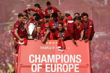 Liverpool's English midfielder James Milner (L) holds the European Champion Clubs' Cup trophy as he stands with teammates (2LtoR) Liverpool's English midfielder Alex Oxlade-Chamberlain, Liverpool's English midfielder Jordan Henderson, Liverpool's Scottish defender Andrew Robertson, Liverpool's Swiss midfielder Xherdan Shaqiri, Liverpool's Brazilian midfielder Roberto Firmino, Liverpool's Belgian striker Divock Origi, Liverpool's Dutch defender Virgil van Dijk, Liverpool's Spanish defender Alberto Moreno and Liverpool's English defender Trent Alexander-Arnold Liverpool's celebrations stretched long into the night after they became six-time European champions with goals from Mohamed Salah and Divock Origi to beat Tottenham -- and the party was set to move to England on Sunday where tens of thousands of fans awaited the team's return. The 2-0 win in the sweltering Metropolitano Stadium delivered a first trophy in seven years for Liverpool, and -- finally -- a first win in seven finals for coach Jurgen Klopp. / AFP / Oli SCARFF