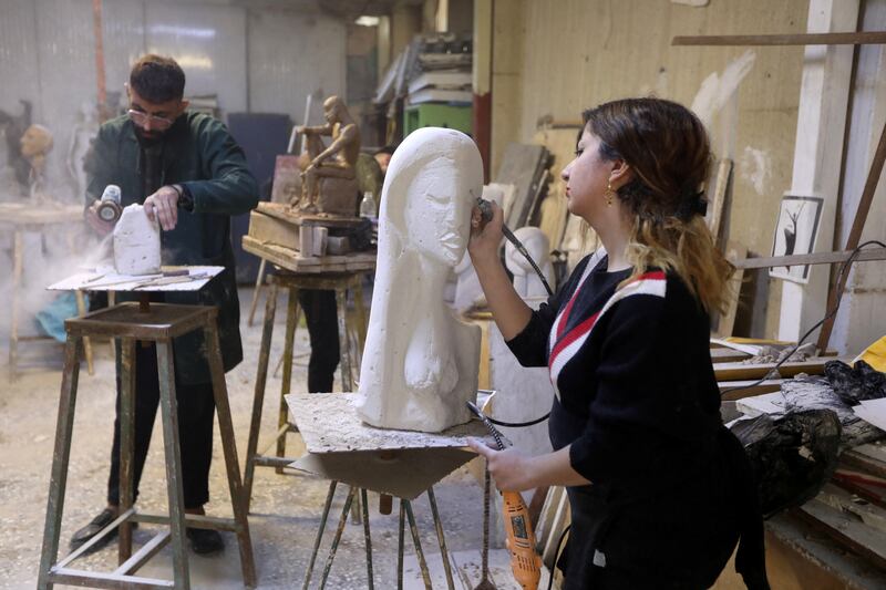 Karmal Mahmood Ali, who works as a sculptor and teacher at the College of Fine Arts, sculpts during a training in Baghdad, Iraq.