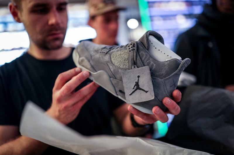 BERLIN, GERMANY - MARCH 31: New KAWS x Air Jordan IV sneakers buyer looks at the shoe during the sale at "Overkill" sneakers store on March 31, 2017 in Berlin, Germany. Several dozen die-hard sneakers fans have taken five days out of their lives to put their names on a list and maintain their presence in order to buy the limited-production shoes. 50 pairs went on sale on March 31 at Overkill, one of only three stores in Germany to sell the shoes. At EUR 350 a pair the shoes carry a hefty price tag, but many of the buyers will resell them, for prices they predict could reach EUR 4,000. Sportswear companies like Adidas and Nike have hired famous designers for limited-production sneakers as the appetite for the shoes by sneakers fanatics has grown into a niche market over the last few years. (Photo by Maja Hitij/Getty Images)