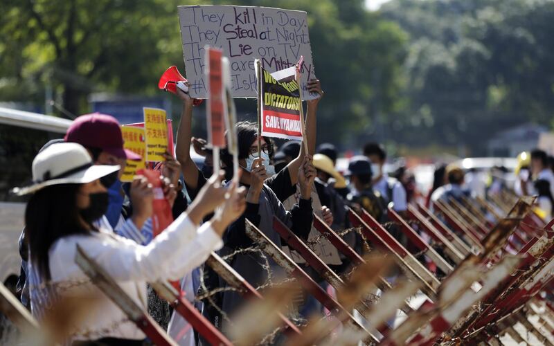 Demonstrators hold placards during a protest against the military coup outside the Chinese Embassy in Yangon. EPA