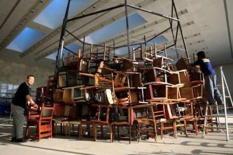 Japanese artist Tadashi Kawamata begins work on his sculptural installation entitled Chairs for Abu Dhabi yesterday at Manarat Al Saadiyat in Abu Dhabi. Ravindranath K / The National