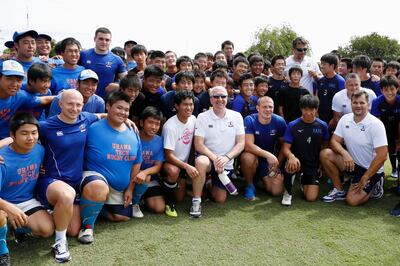 Russian rugby team coach Lyn Jones, center, wearing sunglasses, and his players pose for a group photo with local high school students after a rugby clinic in Saitama, north of Tokyo, Sunday, Sept. 15, 2019.  (Yuki Sato/Kyodo News via AP)