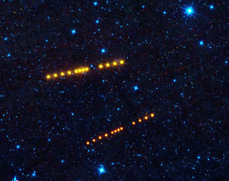 This NASA image obtained April 6, 2020 shows appearing as strings of orange dots, the brightest sets of dots belonging to asteroids Klotho and Lina, both orbiting out in the main asteroid belt between Mars and Jupiter, while smaller, more distant asteroids can also be seen passing through the image. These asteroids were imaged by NEOWISE, the asteroid-hunting portion of the Wide-field Infrared Survey Explorer (WISE) mission. NEOWISE harvests measurements of asteroids and comets from the WISE images and provides a rich archive for solar system objects. - RESTRICTED TO EDITORIAL USE - MANDATORY CREDIT "AFP PHOTO /NASA/JPL-Caltech/UCLA/HANDOUT " - NO MARKETING - NO ADVERTISING CAMPAIGNS - DISTRIBUTED AS A SERVICE TO CLIENTS
 / AFP / NASA / Handout / RESTRICTED TO EDITORIAL USE - MANDATORY CREDIT "AFP PHOTO /NASA/JPL-Caltech/UCLA/HANDOUT " - NO MARKETING - NO ADVERTISING CAMPAIGNS - DISTRIBUTED AS A SERVICE TO CLIENTS
