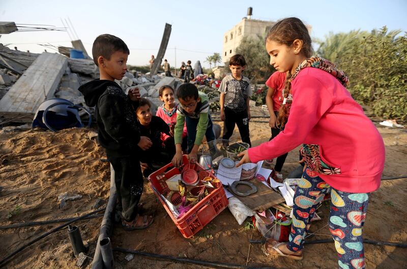 Palestinian children collect objects from a house destroyed in an Israeli air strike in the southern Gaza Strip. Reuters