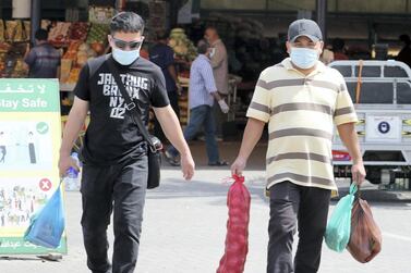 Shoppers wear protectice face masks at Al Aweer Fruit and Vegetable Market in Dubai. Pawan Singh / The National