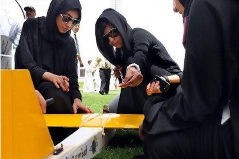Members of the Royal Queenz team, from Abu Dhabi Women's College, prepare their model, and possibly their careers, for launch at the competition.