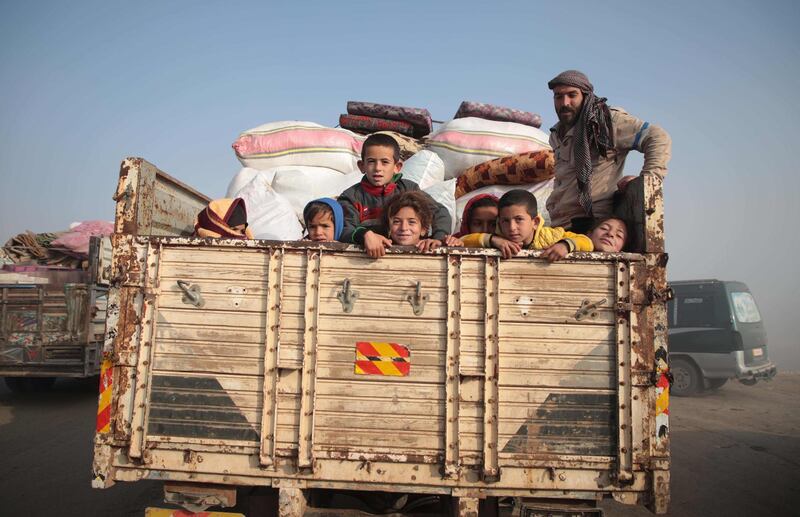 Syrians carrying their belongings on a truck drive towards the northern areas of Syria's Idlib province near the Syrian-Turkish border. AFP