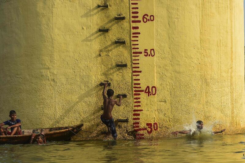 Bangladeshi youths take a bath in the Buriganga River in Dhaka. AFP