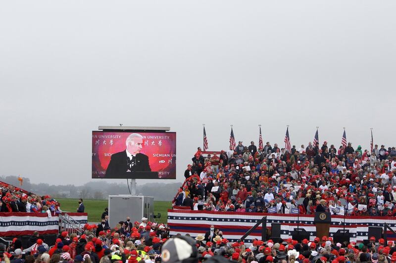 President Donald Trump stands at the podium as a video presentation of Joe Biden and other Democrats is shown at a campaign rally at Lancaster Airport, in Lititz, Pennsylvania. AP Photo