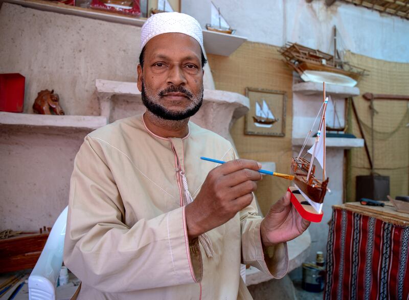 Mujib Rahman from Bangladesh holds his design of a jalboot fishing boat model at his workshop 