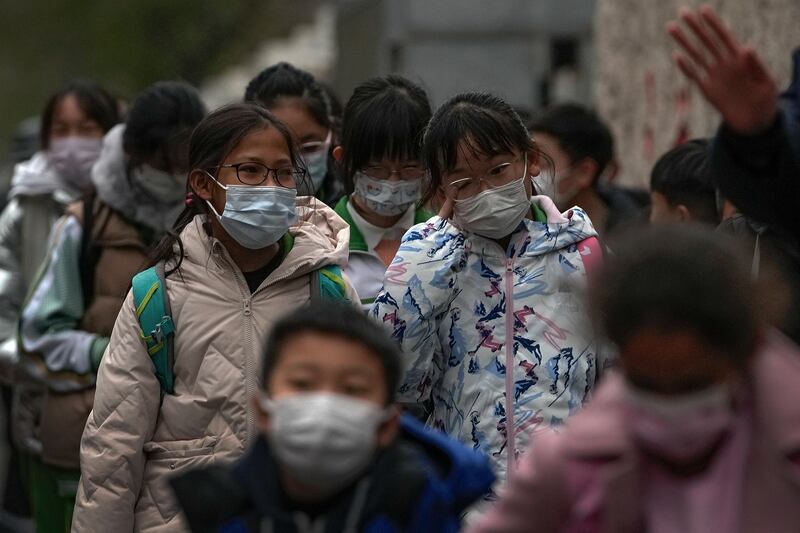 Pupils wear face masks in Beijing.  Despite the global worry, scientists say it remains unclear whether the Omicron variant is more dangerous than other strains of the virus. AP