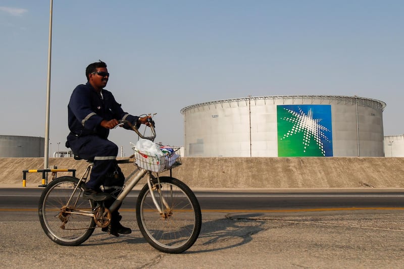 FILE PHOTO: An employee rides a bicycle next to oil tanks at Saudi Aramco oil facility in Abqaiq, Saudi Arabia October 12, 2019. REUTERS/Maxim Shemetov/File Photo