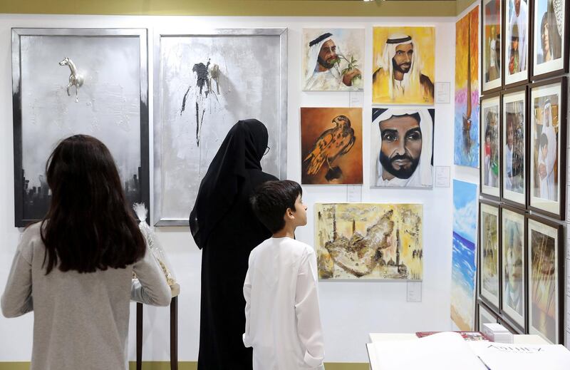 ABU DHABI ,  UNITED ARAB EMIRATES , AUGUST 27 – 2019 :- Visitors looking at the art work at one of the stand during the ADIHEX 2019 held at ADNEC in Abu Dhabi. ( Pawan Singh / The National ) For News/Online/Instagram/Big Picture. Story by Daniel 