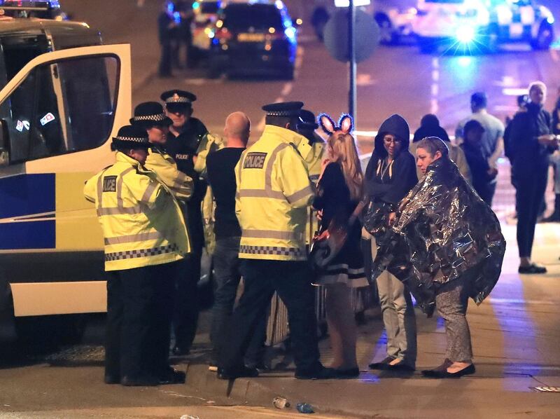 FILE - This s a May 23, 2017 file photo of members of the  emergency services  attending the scene at Manchester Arena after reports of an explosion at the venue during an Ariana Grande gig. An independent review of the counter-terrorism performance by British police and intelligence services rleease on Tuesday Dec. 5, 2017  suggested that the deadly suicide bombing at Manchester Arena might have been prevented if information had been handled differently.  (Peter Byrne/PA, File via AP)