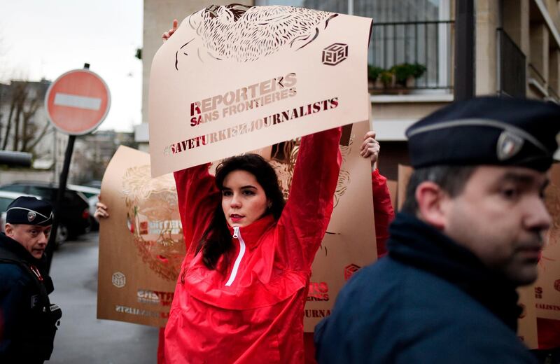 Members of Reporters Without Borders (RSF) hold stencils made by French street artist C215 representing portraits of imprisoned Turkish journalists. Stephane de Sakutin / AFP Photo