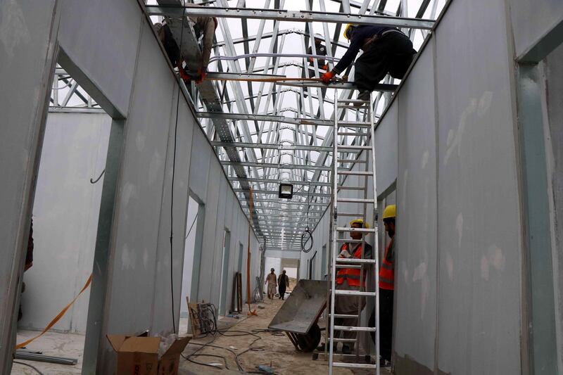 Afghan workers build a makeshift hospital comprising of 100 beds in Herat, Afghanistan.  EPA