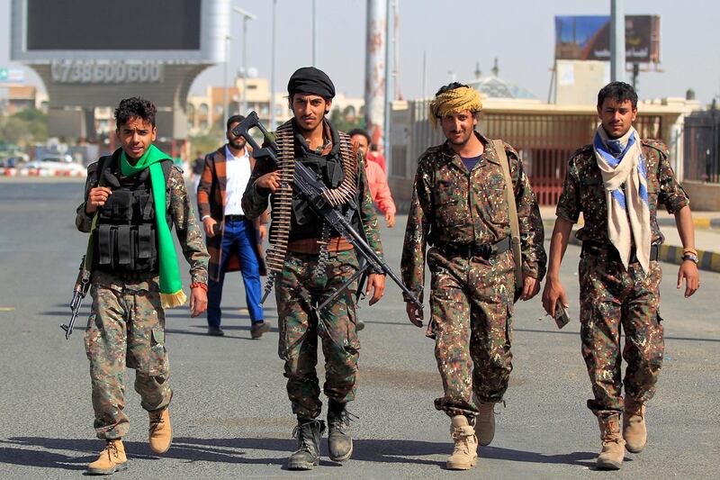 Security forces loyal to the Huthi rebels walk while on duty during a mass wedding for thousands of couples including the poor, handicapped, and wounded, in Yemen's Huthi-held capital Sanaa on December 9, 2020.  / AFP / Mohammed HUWAIS
