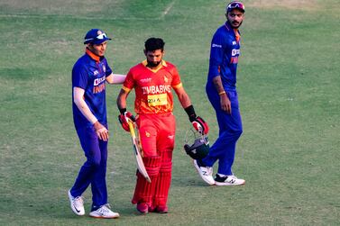 Zimbabwe's Sikandar Raza (C) is consoled by India players after loosing his wicket during the third one-day international (ODI) cricket match between Zimbabwe and India at the at the Harare Sports Club in Harare on August 22, 2022.  (Photo by Jekesai NJIKIZANA  /  AFP)